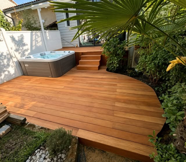 Terrasse en bois aux contours arrondis et escalier, réalisation Sibrac Charpente